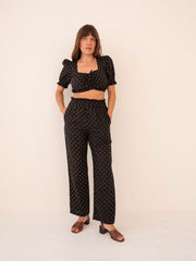 Woman wearing a black polka dot outfit on a white background